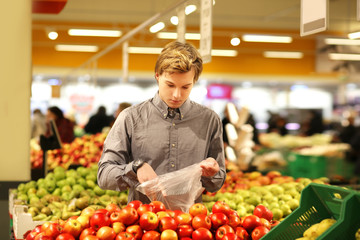 Young man buying vegetables at the market