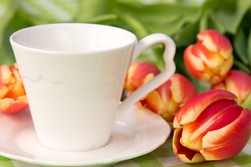 Fototapeta na wymiar Coffee cup and bunch of tulips