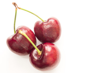 Three red cherry on white background