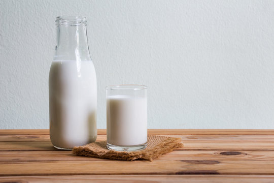 Fresh milk on wooden table over wall background