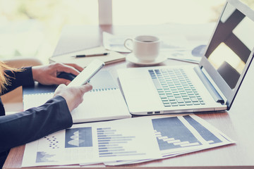 Close Up of woman hands using mobile phone and laptop computer with blank copy space screen for your advertising text message or content business in the Vintage effect.