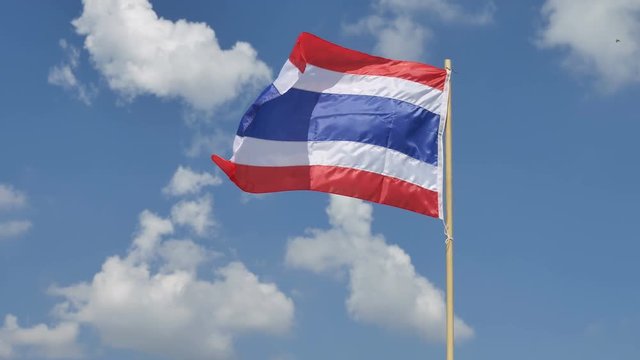 Thai flag moving by wind on blue sky background.