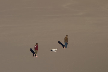 two men with a dog in the desert