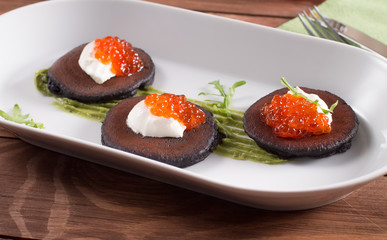 Traditional russian blini with sour cream and red caviar. Selective focus