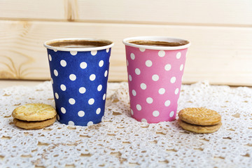 two paper cups of coffee and oatmeal cookies on wooden background