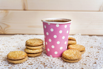 paper cup of coffee and oatmeal cookies on wooden background