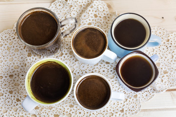 Many cups of coffee on wooden table, top view