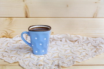blue coffee cup with white dots  on a wooden background