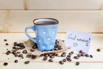 small  coffee mug with white dots  and  good morning message on a wooden background