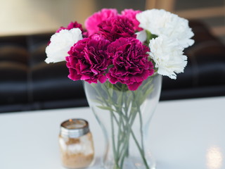 flowers in  vase on wooden table on natural background
