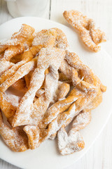 Faworki - Traditional Polish cookies served at Fat Thursday.  Cookies and tulip bouquet on white wooden background
