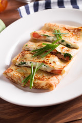 Healthy Breakfast crepes with bacon, cheese, greens, tomatoes on a wooden table. Selective focus