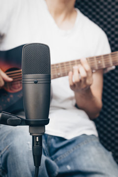 studio microphone recording on acoustic guitarist background