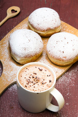 Classic donuts with powdered sugar, on wooden background