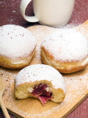 Classic donuts with powdered sugar, on wooden background