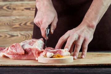 Obraz na płótnie Canvas Butcher cutting pork meat