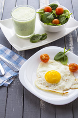 Food fried egg spinach salad wood background
