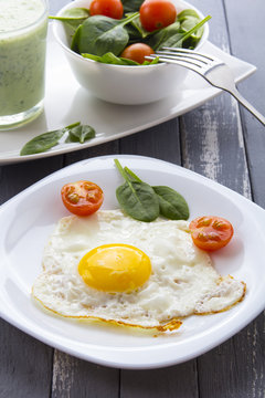 Food fried egg spinach salad wood background
