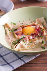 Healthy Breakfast crepes with bacon, cheese, greens, tomatoes on a wooden table. Selective focus