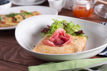 Healthy Breakfast crepes with bacon, cheese, greens, tomatoes on a wooden table. Selective focus