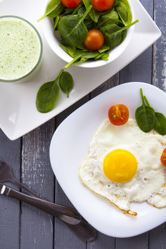 Food fried egg spinach salad wood background
