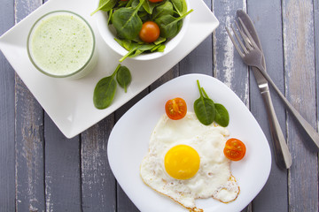 Food fried egg spinach salad wood background
