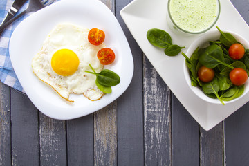 Food fried egg spinach salad wood background
