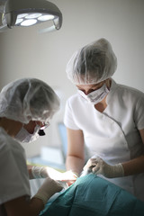 The dentist and assistant perform prosthetic jaw of the patient in the clinic