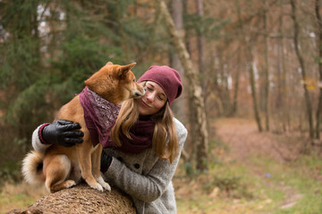 Eine hünsche Frau umarmt ihren Hund 