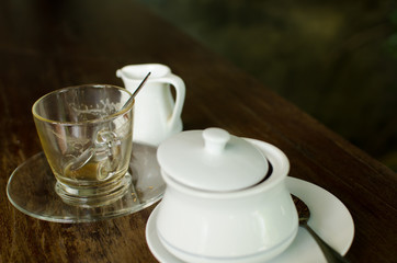 The empty ceramic cup after finish drink coffee with glass plate and tea spoon