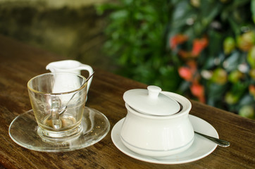 The empty ceramic cup after finish drink coffee with glass plate and tea spoon