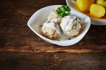 Three meatballs served with a creamy white sauce