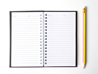 Top view of open spiral blank notebook with pencil on white desk background