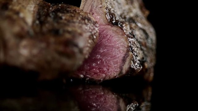 CLOSE UP FOOD: rack of lamb is cut in half slow motion