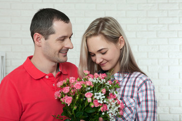 Valentine's day, anniversary, event concept - young woman receives a gift of a bouquet of flowers from her boyfriend