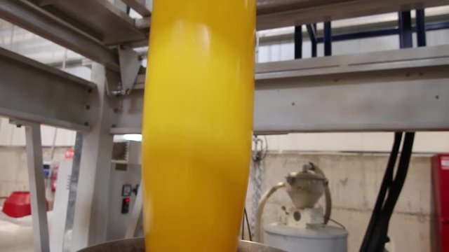 Extrusion of yellow plastic in a factory
