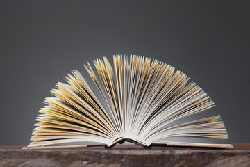 Open Book forming a fan on a wooden Table © mvc_stock