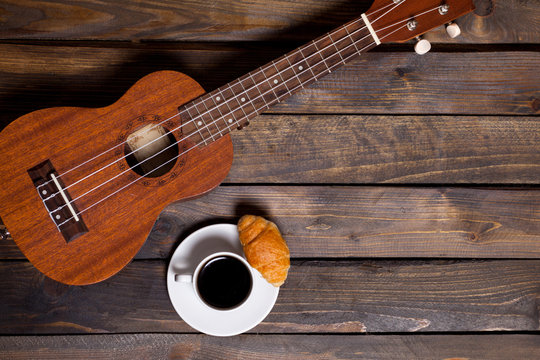 Ukulele ukulele with cup of coffee and croissant