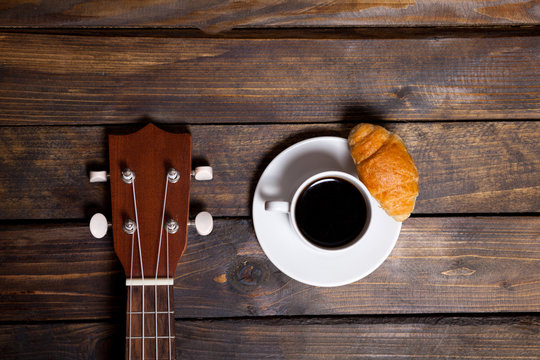 Ukulele ukulele with cup of coffee and croissant
