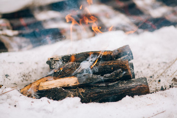 Burning firewood in campfire for winter picnic.