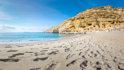 Panorama of Matala beach with the caves on the rocks that were used as a roman cemetery and at the...