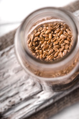 Wheat seeds in a glass jar on a white rustic board