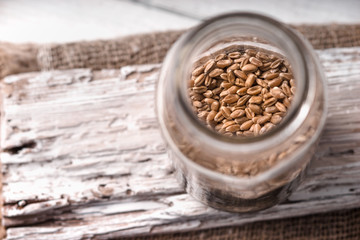 Wheat seeds in a glass jar on a white rustic board side view