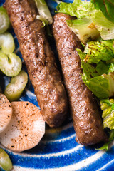 Chevanchichi with lettuce and daikon and celery on a blue plate top view