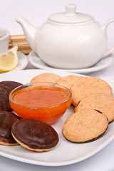 Coconut cookies "buttons" on a white plate with a serving of tea drinking tea with jam