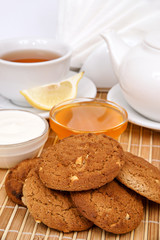 Oatmeal cookies with nuts on a wooden background with the filing of tea with jam