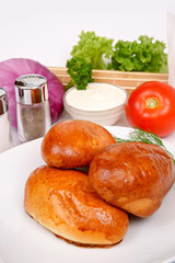 Home baked pies on a white plate with fennel, parsley and lettuce