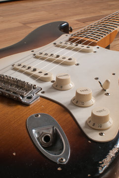Vintage Fender Stratocaster electric guitar sunburst body close up with worn volume and tone knobs