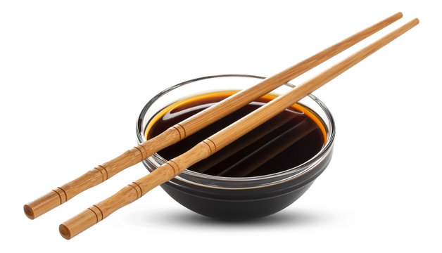 Soy sauce and chopsticks isolated on white