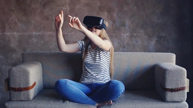 shot of woman getting experience in using VR-headset at home